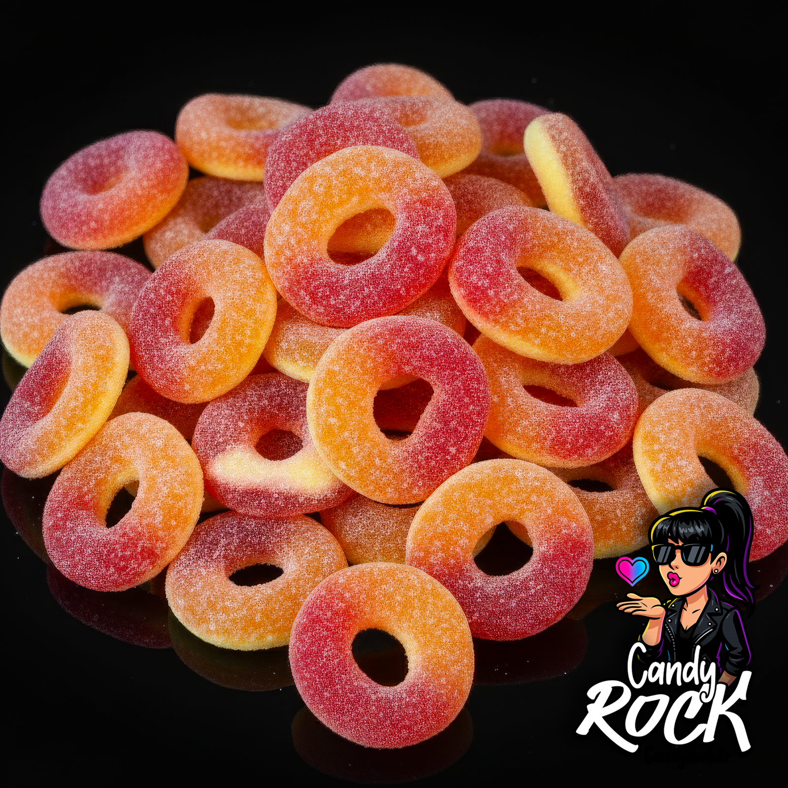 Anneaux acidulés bicolores rouge et orange saveur pêche en présentation générale sur fond noir, texture sucrée CandyRock.