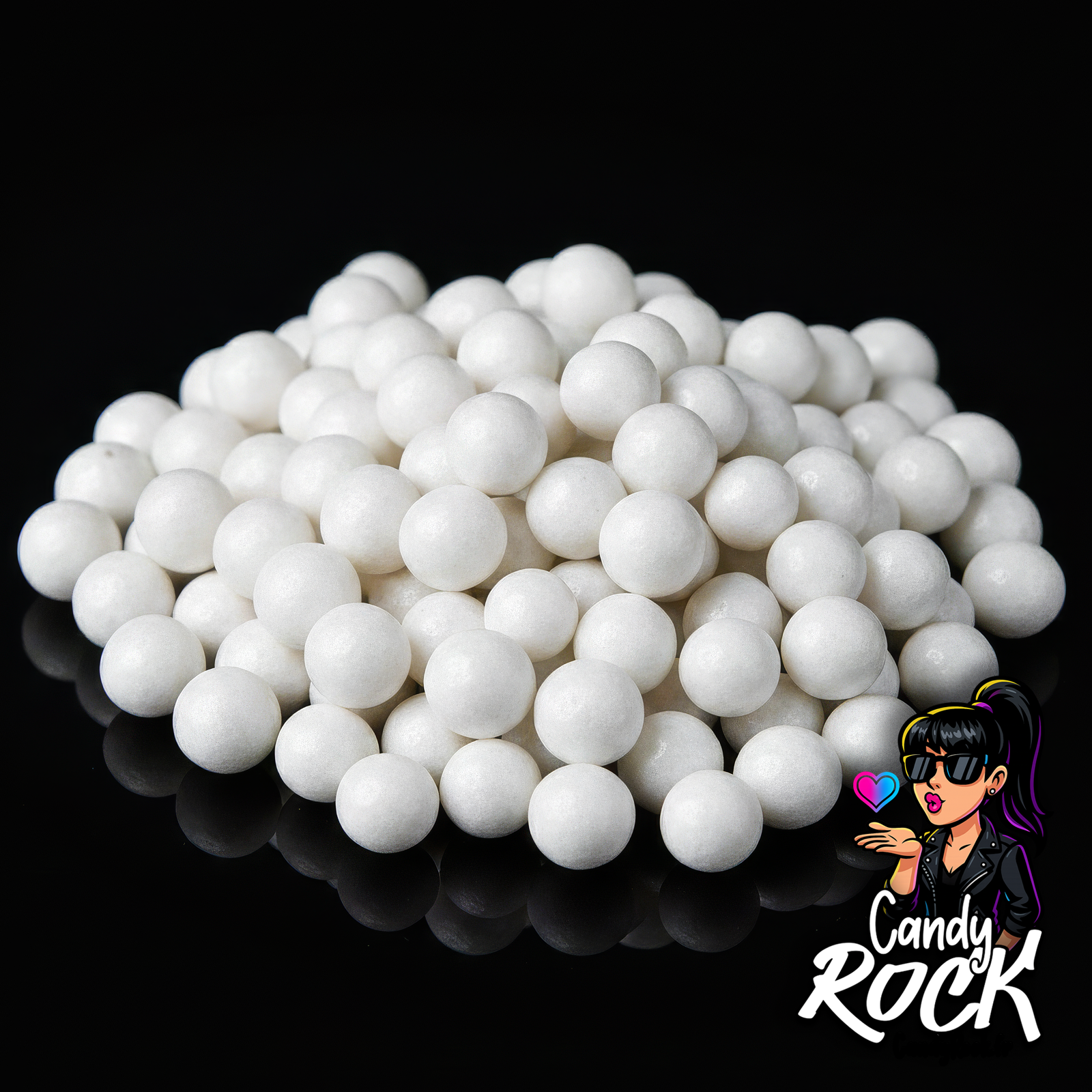 Gros plan de billes de céréales blanches Tukan montrant leur surface lisse et nacrée sur fond noir CandyRock.