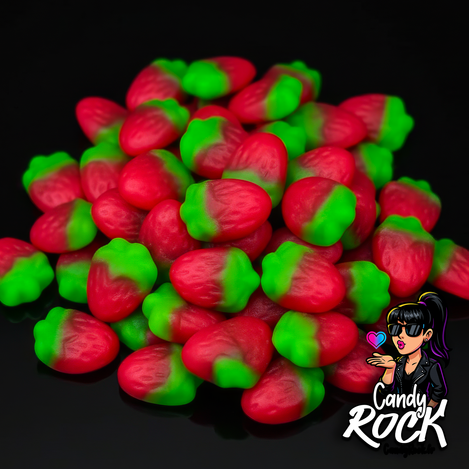 Mini fraises sauvages lisses rouge et vert en tas sur fond noir, présentation brillante CandyRock.