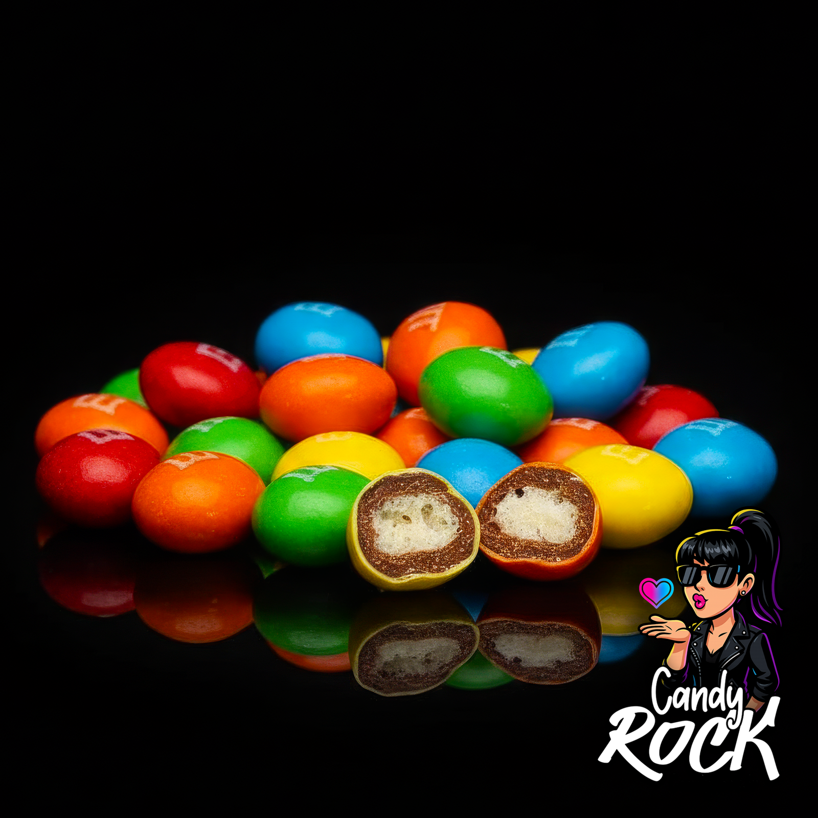 Gros plan de M&M’s Crispy multicolores sur fond noir montrant l’intérieur croustillant d’une dragée ouverte, CandyRock.