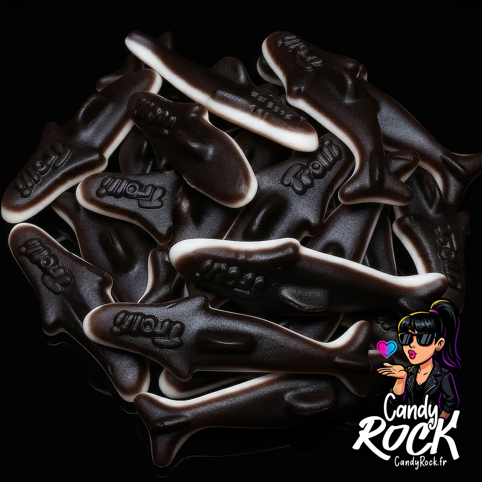 Bonbons orques gélifiées lissées Trolli noir et blanc en tas sur fond noir, texture brillante CandyRock.