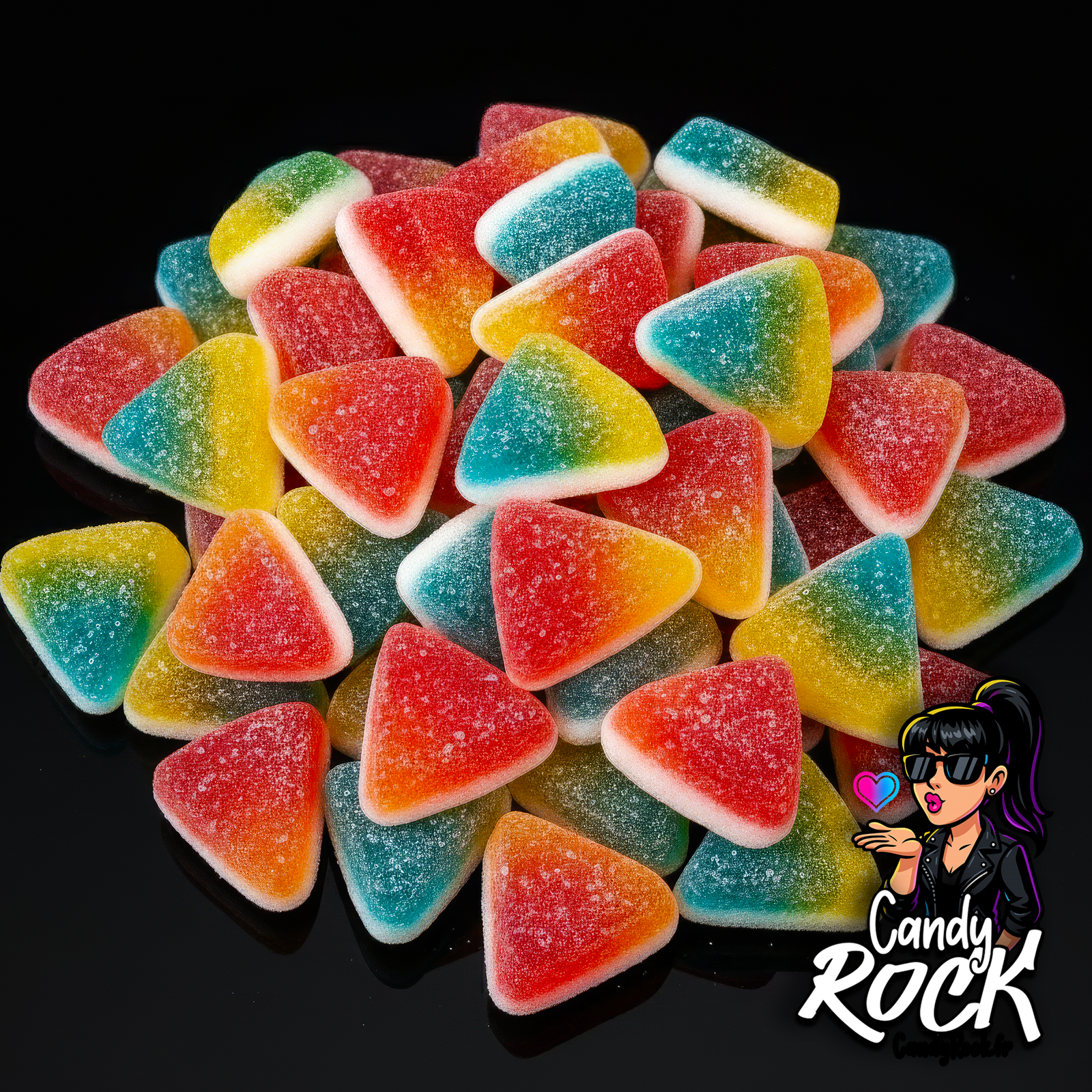 Assortiment de tartitas tricolores sucrées triangulaires en vrac, vues de dessus sur fond noir, CandyRock.